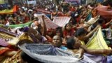 Hindu devotees hold up scarves to receive rice as offerings being distributed by the temple authority on the occasion of the Annakut festival in Kolkata, India.