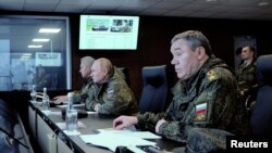 Presiden Rusia Vladimir Putin (tengah), Menhan Sergei Shoigu (kiri) dan Kepala Staf Angkatan Bersenjata Rusia Valery Gerasimov mengawasi latihan militer "Vostok-2022" di tempat pelatihan Sergeyevsky di wilayah Primorsky timur jauh, Rusia 6 September 2022. 