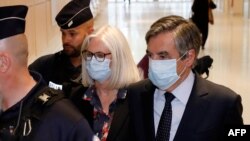 Mantan perdana menteri Perancis Francois Fillon dan istrinya, Penelope Fillon, meninggalkan gedung pengadilan Paris setelah pembacaan putusan, Senin, 29 Juni 2020.