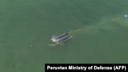 This handout picture released by the Peruvian Ministry of Defense shows a capsized fishing boat during a helicopter flight by Peru's Minister of Defense, Walter Enrique Astudillo, as heavy tidal waves hit in Tumbes, Tumbes Province, Peru, Dec. 28, 2024.