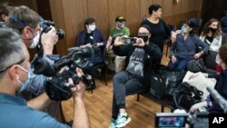Sutradara teater dan film terkemuka, Kirill Serebrennikov (tengah), mengambil foto para awak media yang memotretnya menjelang sidang di pengadilan Moskow, Rusia, 22 Juni 2020. 