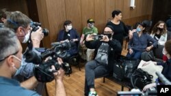 Russian theater and film director Kirill Serebrennikov, center, takes a photo of the media prior to his hearing in a court, in Moscow, Russia, June 22, 2020. 