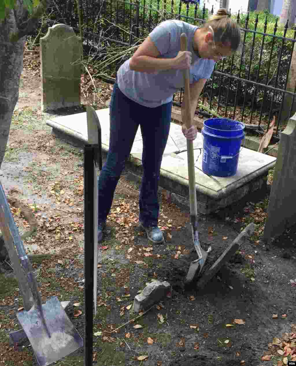 Leigh Yarbrough, a student at the American College of the Building Arts, restores a tombstone at a historic cemetery in Charleston, S.C. (J. Taboh/VOA News)