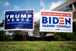 FILE PHOTO: Yard signs supporting U.S. President Donald Trump and Democratic U.S. presidential nominee and former Vice President Joe Biden are seen outside of an early voting site at the Fairfax County Government Center in Fairfax, Virginia, U.S.,…