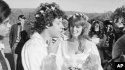 Arlo Guthrie sings 'Amazing Grace' to his new bride, Jackie Hyde, at their wedding ceremony on Guthrie's Washington, Mass., farm on Oct. 9, 1969. Alice Brock of 'Alice's Restaurant' is second from the right in the background.