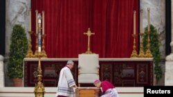 FILE: Archbishop Georg Gaenswein kisses the Bible on top of former Pope Benedict's coffin during his funeral, in St. Peter's Square at the Vatican, January 5, 2023. 