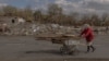 FILE - An elderly woman collects wood ahead of the winter in an area that was recently shelled in the village of Yasenove, south of the city of Pokrovsk, Donetsk region, on Oct. 8, 2024, amid the Russian invasion of Ukraine.