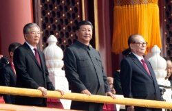 FILE - Chinese President Xi Jinping, center, with former presidents Jiang Zemin, right, and Hu Jintao, left, attend the celebration to commemorate the 70th anniversary of the founding of Communist China, in Beijing, Oct. 1, 2019.