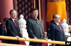 Chinese President Xi Jinping, center, with former presidents Jiang Zemin, right, and Hu Jintao, left, attend the celebration to commemorate the 70th anniversary of the founding of Communist China, in Beijing, Oct. 1, 2019.