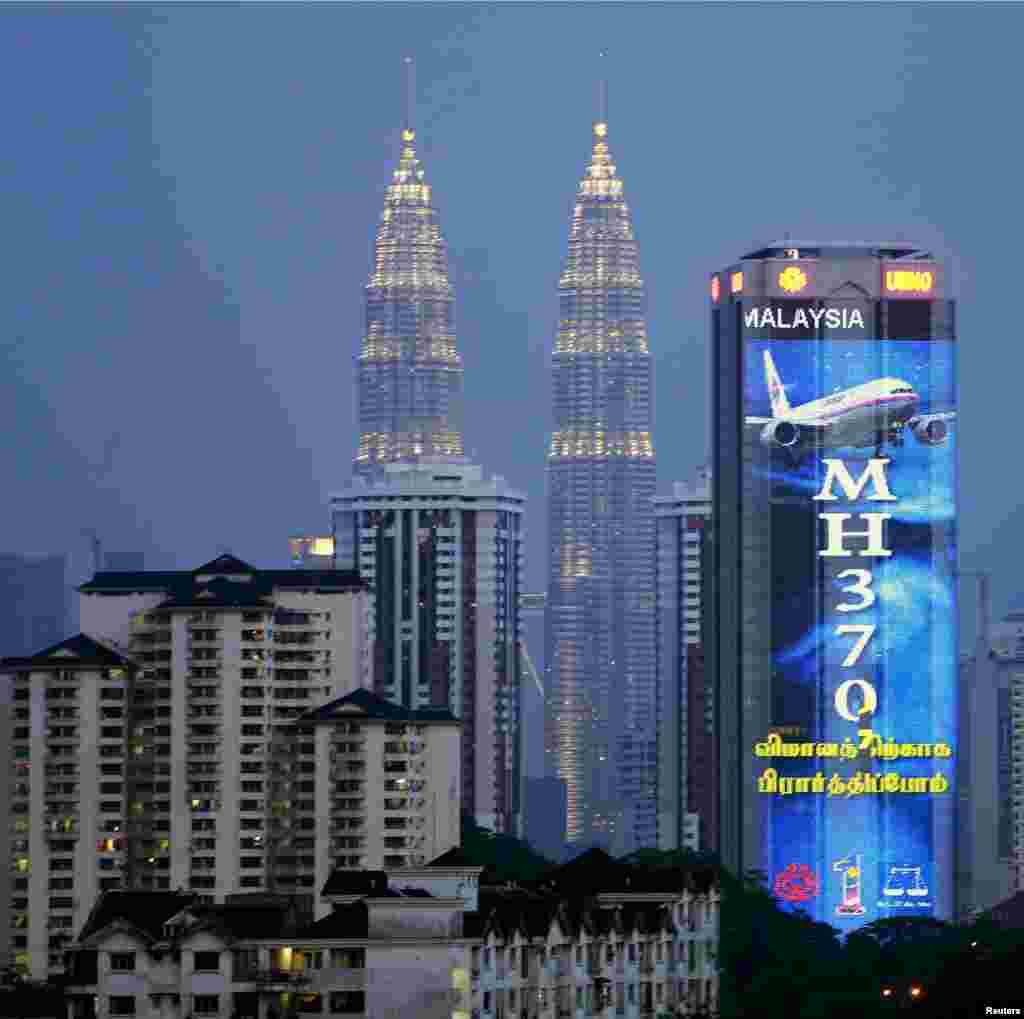 در پایتخت مالزی، در کنار برج های دوقلوی تجاری تصویری به نشانه حمایت از پرواز گمشده مالزی دیده می شود - کوآلا لامپور، ۱۹ مارس ۲۰۱۴