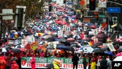 Thousands of teachers and supporters hold signs in the rain during a rally, Jan. 14, 2019, in Los Angeles. Tens of thousands of Los Angeles teachers went on strike Monday for the first time in three decades after contract negotiations failed.