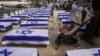 People stand by Israel flag-covered coffins meant to symbolize the price Israel will pay for agreeing to a ceasefire with Hamas in a demonstration against the deal in Jerusalem on Jan. 16, 2025. 