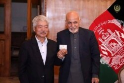 Afghanistan's President Ashraf Ghani, right, and Japanese Dr. Tetsu Nakamura pose in this undated photo in Kabul, Afghanistan.
