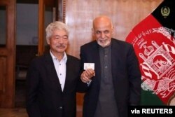 Afghanistan's President Ashraf Ghani, right, and Japanese Dr. Tetsu Nakamura pose in this undated photo in Kabul, Afghanistan.