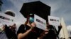 FILE - Protesters hold signs of the Hong Kong-Thailand-Taiwan network (Milk Tea Alliance) during a rally to demand that the government resign, that the parliament dissolve and that new elections be held, in Bangkok, Thailand, Aug. 16, 2020.