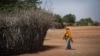 FILE - In this Dec. 19, 2017 photo, a Somali girl walks near a fence surrounding a hut at Dadaab refugee camp.