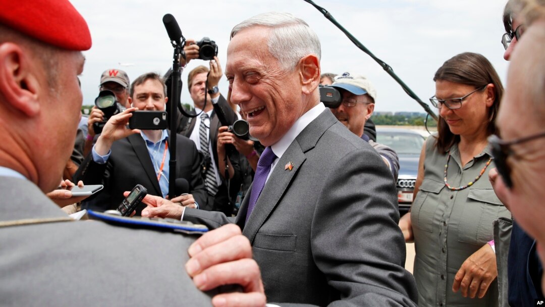 Defense Secretary Jim Mattis smiles at a member of the German army as he speaks with the media at the Pentagon, June 20, 2018, in Washington. 