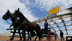 El ataúd del legislador John Lewis tirado por un carruaje con dos caballos cruza el puente Edmund Pettus en Selma, Alabama, el domingo 26 de julio de 2020.