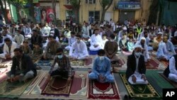 Warga melakukan salat Idul Fitri di Kabul, Afghanistan hari Minggu (24/5) setelah pemerintah dan kelompok Taliban menyetujui gencatan senjata 3 hari.