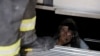 An elderly person trapped in an elevator reacts as firefighters assist in her rescue during a blackout in Santiago, Chile, Feb. 25, 2025.