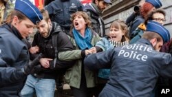 Polisi menahan sekelompok orang di Place de la Bourse di Brussels, Belgia (2/4). (AP/Geert Vanden Wijngaert)