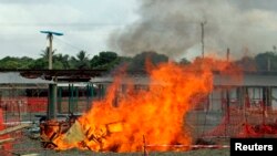 A portion of a Medecins Sans Frontieres (MSF) Ebola treatment unit burns as the MSF begins decommissioning the facility in Monrovia, Liberia, Jan. 26, 2015.