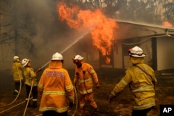 Firefighters battle the Morton Fire as it burns a home near Bundanoon, New South Wales, Australia, on Thursday, Jan. 23, 2020. (AP Photo/Noah Berger)