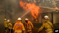 Firefighters battle the Morton Fire as it burns a home near Bundanoon, New South Wales, Australia, on Thursday, Jan. 23, 2020. (AP Photo/Noah Berger)