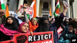 Indian women hold placards and shout slogans during a protest against a new citizenship law that opponents say threatens India's secular identity in Bangalore, Dec. 26, 2019.