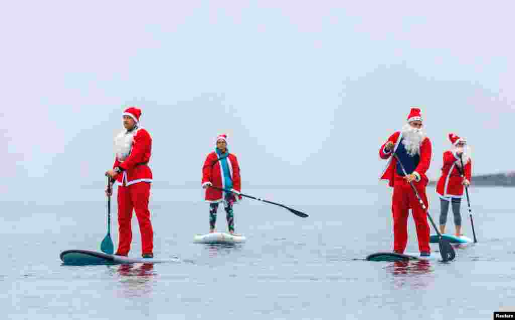 Personas vestidas como Pap&#225; Noel reman en Navidad en Pula, Croacia. Lo hacen para un evento que busca recaudar fondos para los ancianos en Pula [Reuters].