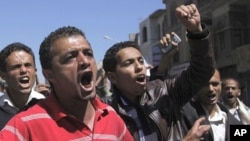Anti-government protester shout slogans during a demonstration in Sanaa, February 15, 2011