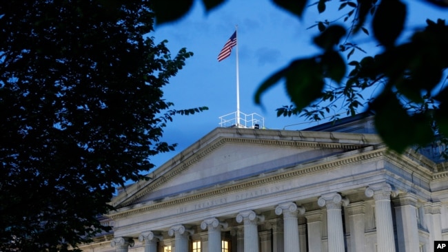 FILE - This June 6, 2019, photo shows the U.S. Treasury Department building at dusk in Washington.