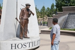 Donald Shaw mira una escultura en el parque de reconciliación John Hope Franklin en Tulsa, Okla.