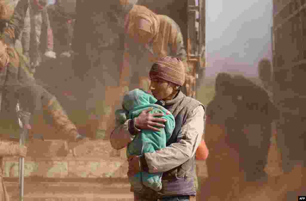 People who fled battles between Syrian Democratic Forces (SDF) and fighters from the Islamic State (IS) group in the Syrian village of Baghouz, arrive after crossing a desert in the back of a truck to a region controlled by the SFD in the countryside of the Deir Ezzor province, Jan. 26, 2019.