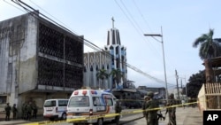 Les forces de sécurité sur les lieux de l'explosion de deux bombes devant une cathédrale catholique de Jolo, capitale de la province de Sulu, dans le sud des Philippines, le dimanche 27 janvier 2019. (AP Photo / Nickee Butlangan)