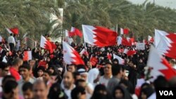 Demonstran anti-pemerintah berbaris dalam aksi protes di Riffa, Bahrain, Jumat (11/3), di mana polisi membentuk barikade untuk mencegah puluhan ribu demonstran bergerak menuju halaman istana kerajaan.