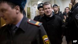 FILE - Russian opposition activist Leonid Razvozzhayev is escorted into a court room in Moscow, Russia, April 1, 2013. Amnesty International says he was abducted by Russian state security agents operating in Ukraine.