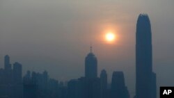 FILE - The skyline of the business district is silhouetted at sunset in Hong Kong.