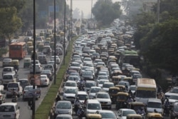 Vehicles queue at a traffic light on a hazy morning in New Delhi, India, Oct.16, 2020.