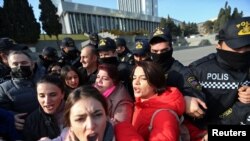 Polisi anti huru-hara mengawal para jurnalis yang melakukan aksi protes terhadap sebuah RUU di depan gedung parlemen di Baku, Azerbaijan (foto: dok). 