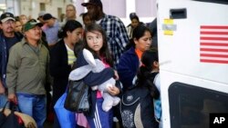 FILE - file photo, immigrants from El Salvador and Guatemala, who entered the country illegally, board a bus after they were released from a family detention center in San Antonio, Texas, July 7, 2015.