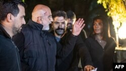 Journalist and writer Ahmet Altan (C) waves to his daughter Senem Altan (R) as he is detained on November 12, 2019, at Kadikoy neighbourhood in Istanbul. 