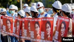 Demonstrators hold cards with the image of Aung San Suu Kyi during a protest against the military coup, in Naypyitaw, Myanmar, February 15, 2021. REUTERS/Stringer 