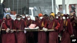 Tibetan monks carry the body of a quake victim during a funeral procession in Jiegu, Yushu county, in China's northwestern province of Qinghai on April 21, 2010.