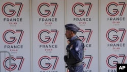 G7 정상회의(6월 15~17일 예정)를 앞둔 2026년 6월 11일 목요일, 프랑스 동부 에비앙레뱅에서 한 프랑스 경찰관이 G7 로고 옆을 지나가고 있다.