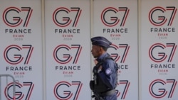 一名法国警察在法国东部城市埃维昂七国集团峰会的标志前经过。（2026年6月11日）