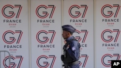 一名法国警察在法国东部城市埃维昂七国集团峰会的标志前经过。（2026年6月11日）