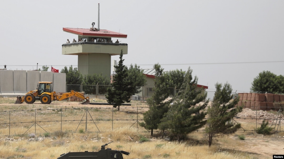 Beberapa tentara Turki berjaga di sebuah pos pengamatan di penyeberangan Atmeh di perbatasan Turki-Suriah, tampak dari Provinsi Idlib, Suriah, 31 Mei 2019. (Foto: Khalil Ashawi/Reuters)