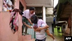 Residents evacuate from their flooded homes due to a swollen river caused by heavy rains and induced by Super Typhoon Man-yi in Tuguegarao City, Cagayan province.&nbsp;&nbsp;Floodwaters submerged houses and highways in the northern Philippines after water released from a dam following Typhoon Man-yi caused a major river to break its banks.