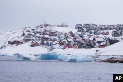 Colored houses covered by snow are seen from the sea in Nuuk, Greenland, March 6, 2025.